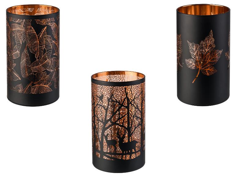 Tři černé svícny s měděnými detaily a různými vzory.