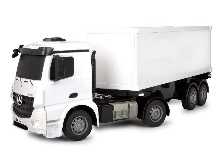 Bílý model hračky nákladního auta Mercedes Arocs s bílým přívěsem.