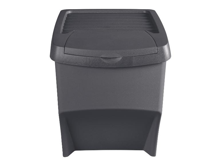 Tmavě šedý plastový odpadkový koš s výkyvným víkem, izolovaný na bílém pozadí.
