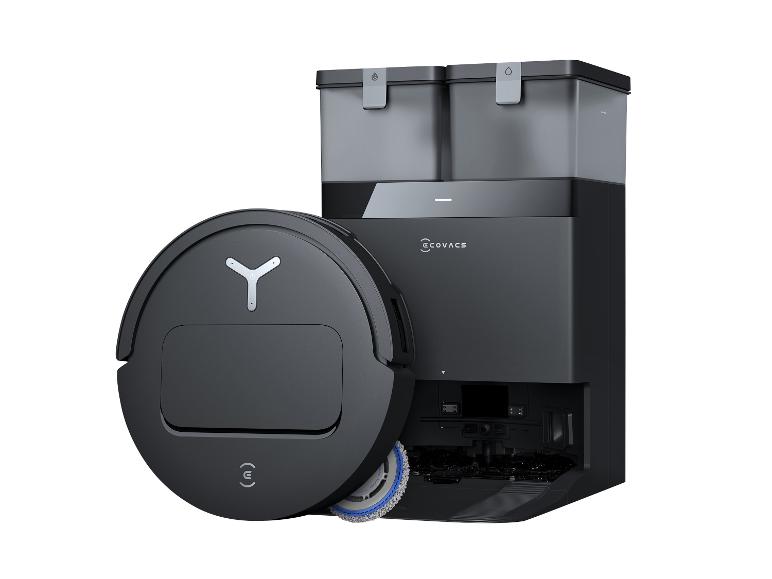 Černý robotický vysavač a automatická vyprazdňovací stanice na bílém pozadí.