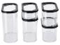 Tři průhledné nádoby na potraviny s černými víčky, různě naskládané.
