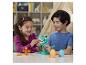 Dvě děti si hrají s dinosaury a vajíčky Play-Doh.
