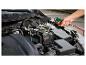 Muž čistí motor auta stlačeným vzduchem