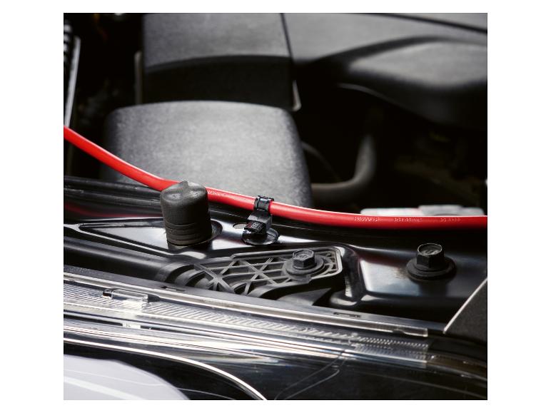 Červené autobateriové kabely v motorovém prostoru vozu.