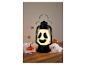 Lampa s obličejem ducha, zdobená pavouky a dýněmi na Halloween.