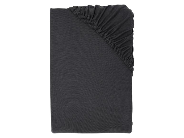 Tmavě šedé prostěradlo z bavlněného žerzeje, složené s elastickými detaily.