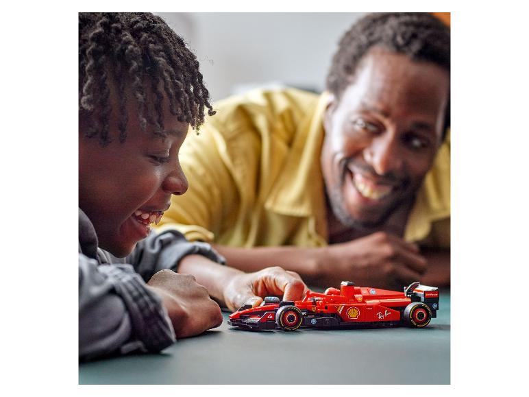 Dítě a otec si hrají s LEGO Ferrari formulí 1.