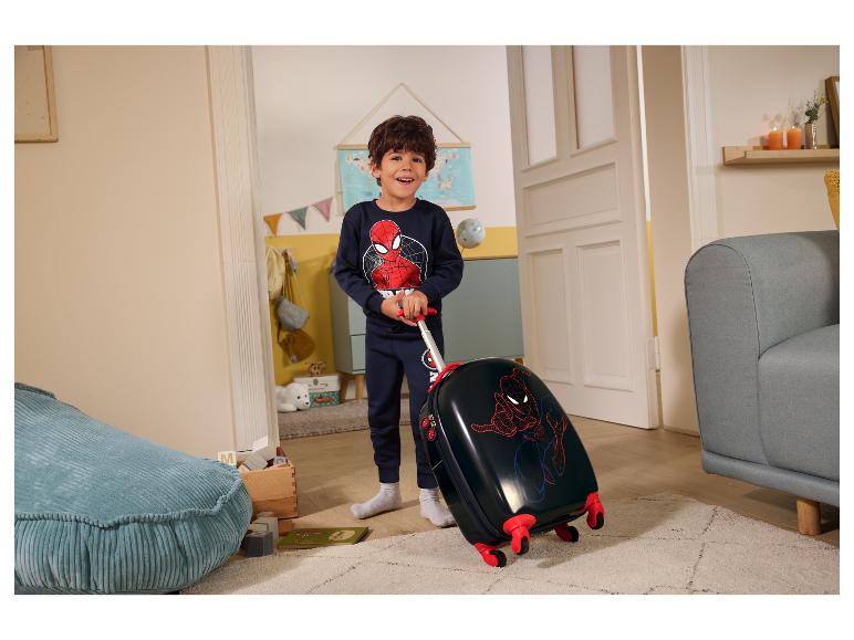 Chlapec v pyžamu Spiderman táhne dětský kufr Spiderman v pokoji.