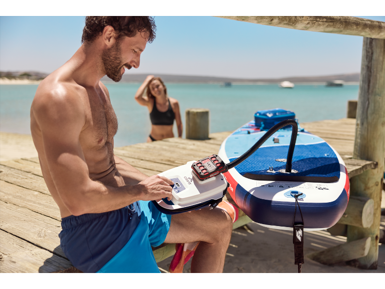 Muž nafukuje paddleboard pumpou Gravit.