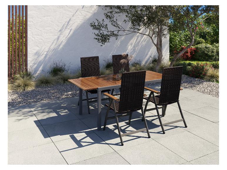 Venkovní jídelní sestava s dřevěným stolem a čtyřmi tmavými židlemi na terase.