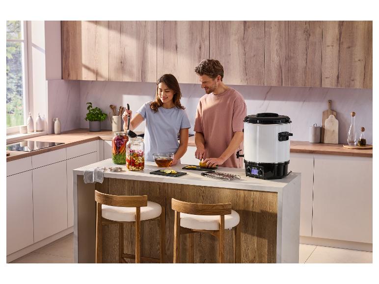 Zavařovací hrnec SILVERCREST® SEAD 1800 B2 na kuchyňském ostrůvku s párem připravujícím jídlo