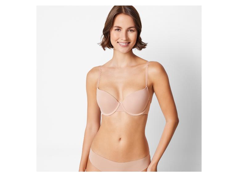 Žena v béžové podprsence a kalhotkách.