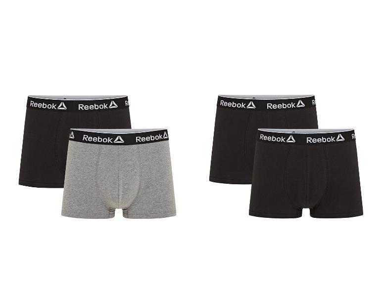 Čtyři boxerky, dvě černé a dvě šedé, značky Reebok.