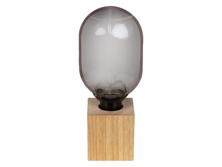 Stolní lampa s dřevěnou základnou a skleněným stínidlem ve tvaru kapsle.