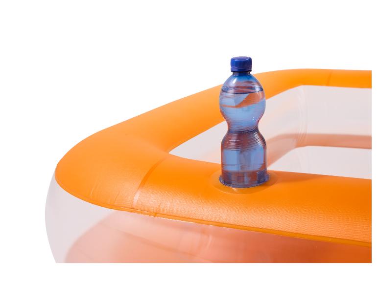 Láhev vody v oranžovém nafukovacím bazénu