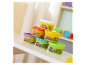Několik malých nádob s plastelínou Play-Doh naskládaných na stole.
