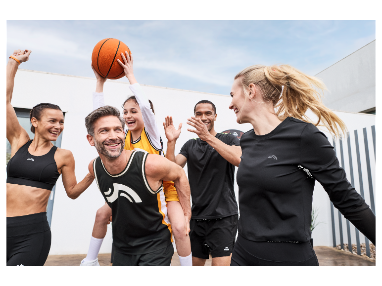 Rodina v sportovním oblečení Craft hraje basketbal.