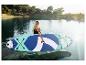Žena s paddleboardem na jezeře, obklopená stromy.