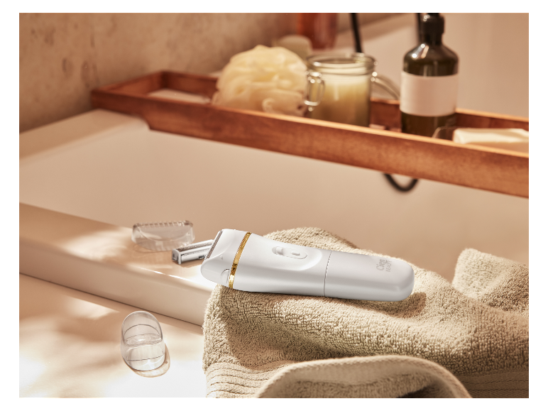Holicí strojek Cien Beauty na ručníku v koupelně.