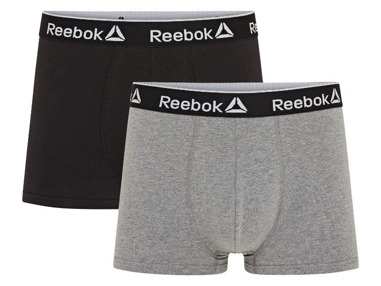 Dva páry boxerů Reebok, jeden černý a jeden šedý.