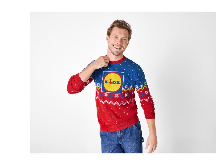 Muž v modro-červeném vánočním svetru Lidl a džínách.