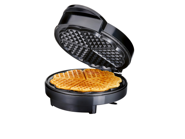Otevřený waflový gril se třemi vaflemi ve tvaru srdce.