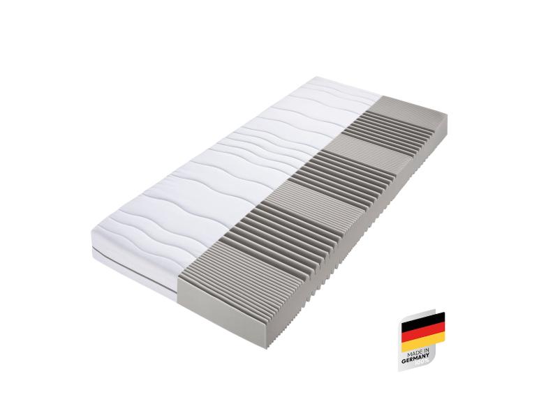 Bílý a šedý matrace s nálepkou 'Made in Germany'.
