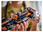 Osoba drží černý a oranžový LEGO McLaren Formule 1 závodní vůz.