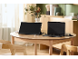 Přenosný monitor a notebook připojené na dřevěném stole ve světlém pokoji.