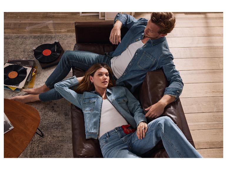 Pár v džínách relaxuje na kožené pohovce.