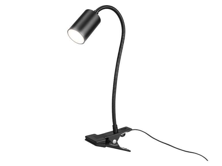 Černá stolní lampa s klipem a flexibilním ramenem, vyzařující jasné světlo.