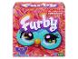 Krabička interaktivní hračky Furby s velkýma očima a barevnou srstí.