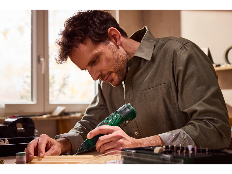 Muž používá rotační nástroj Parkside k opracování dřeva.