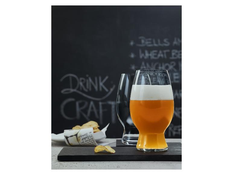 Řemeslné pivo v elegantních sklenicích s bramborovými lupínky.