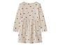 Béžové dívčí šaty s černými srdíčky, dlouhými rukávy a nabíranou sukní.
