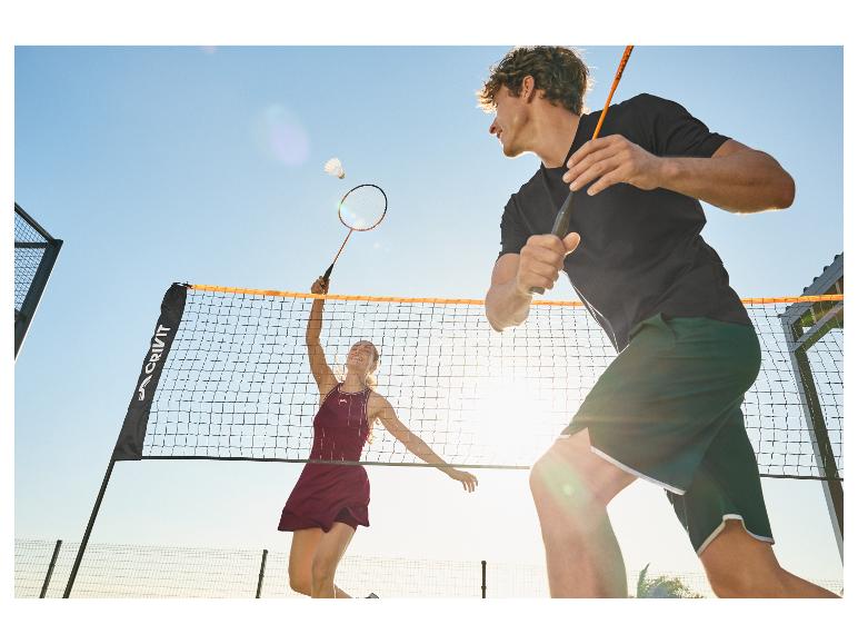 Dva hráči badmintonu, muž a žena, na venkovním kurtu.