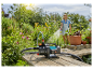 Zahradní vodní pumpa Gardena a hadice na zahradě.