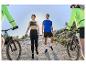 Lidé v Karrimor sportovním oblečení jezdí na horských kolech slunečný den.