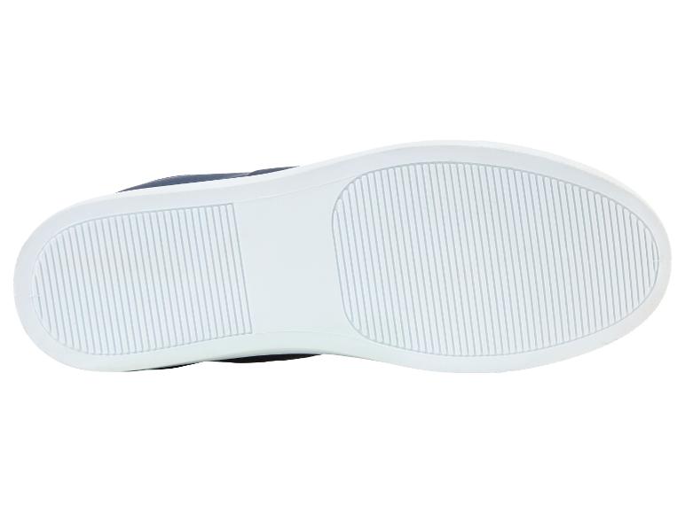 Bílé podrážky tenisek s tmavě modrým svrškem.