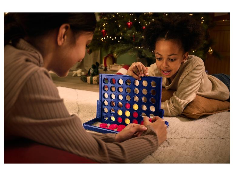 Dvě děti hrají Connect Four o Vánocích.