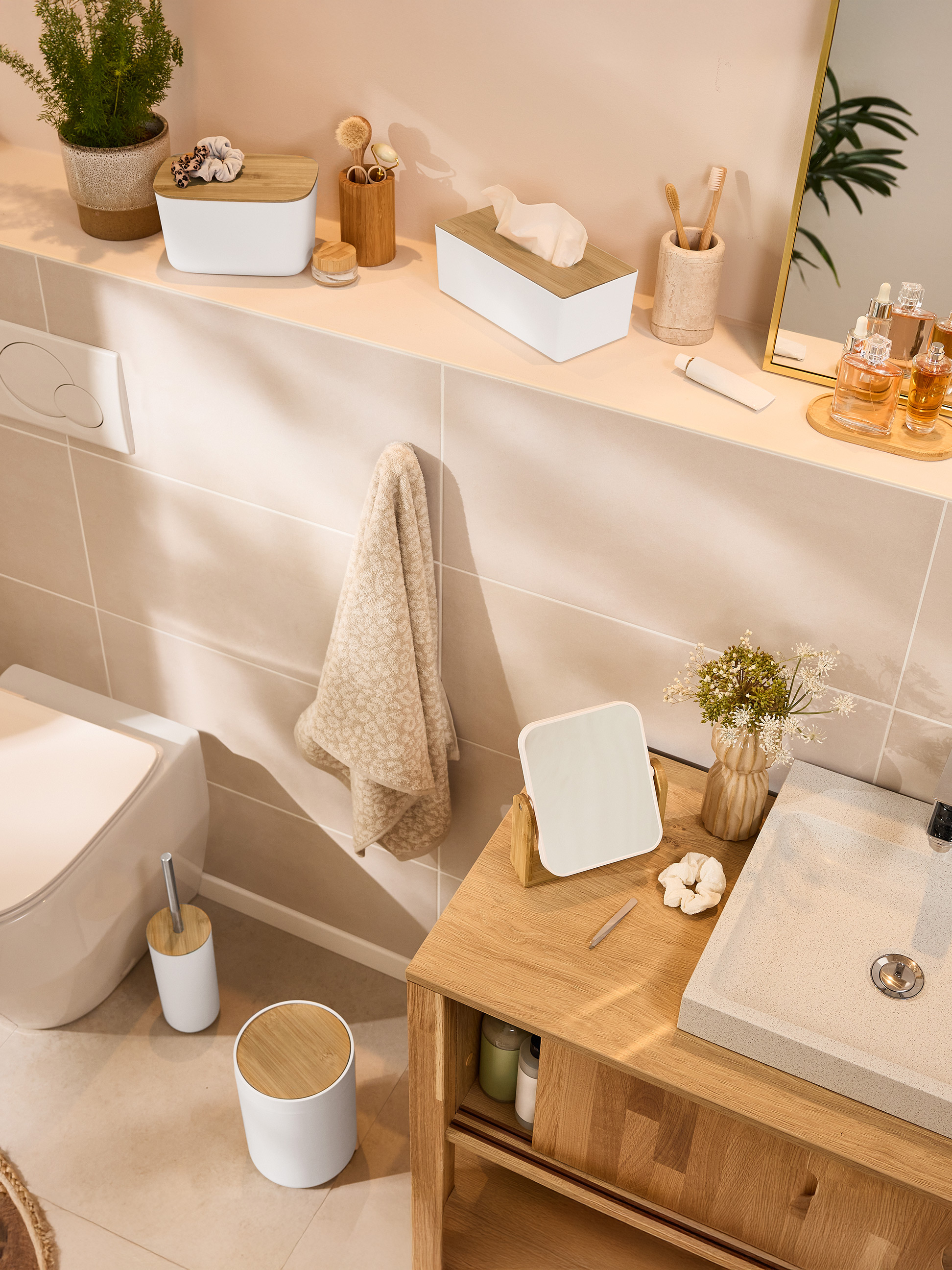 Koupelna s bambusovými doplňky, toaletou a umyvadlem.