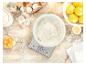 Ingredience na pečení: mouka v míse na váze, vejce, citrony, cukr na dřevěném stole.