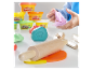Play-Doh plastelína a dřevěné nástroje v dětských rukou.