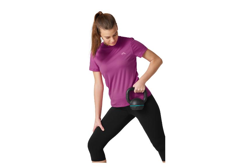 Žena ve fialovém a černém sportovním oblečení drží černý kettlebell.