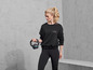 Žena v Active Vibes tréninkovém oblečení drží kettlebell.