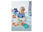 Chlapec si hraje s dřevěnými puzzle a dřevěnými hodinami.