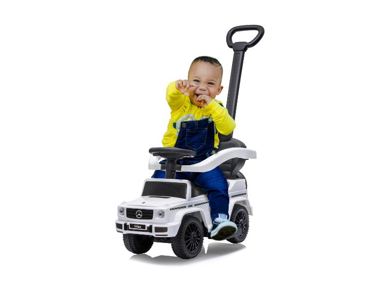 Malé dítě si hraje s hračkářským autem Mercedes-Benz třídy G.