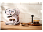 Růžový espressový kávovar Silvercrest na dřevěné desce.
