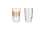 Dvě sklenice latte macchiato: jedna plná, druhá prázdná.