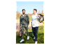 Dva muži jdou po golfovém hřišti s cestovními taškami.
